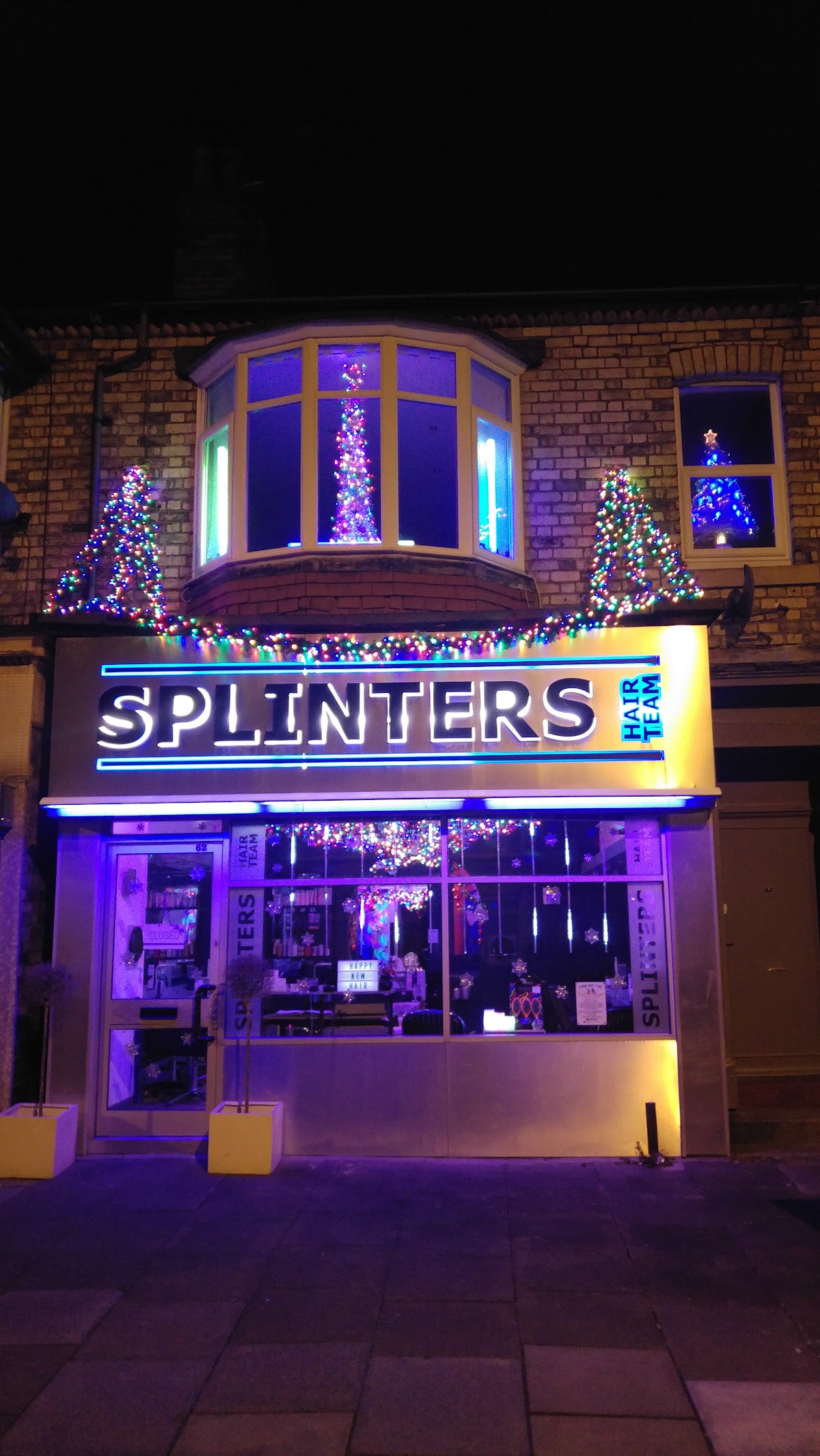 The Splinters shopfront lit up at night with festive lights